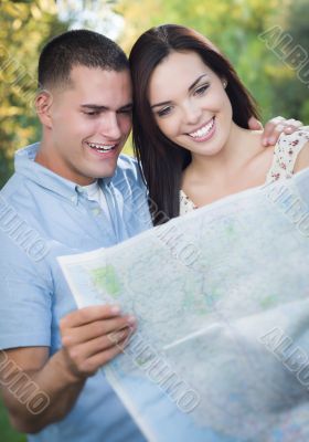 Mixed Race Couple Looking Over Map Outside Together