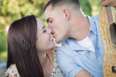 Mixed Race Couple Portrait with Guitar in Park