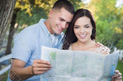 Mixed Race Couple Looking Over Map Outside Together