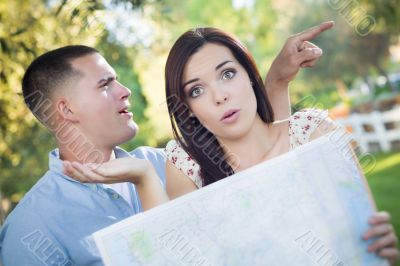 Lost and Confused Mixed Race Couple Looking Over Map Outside