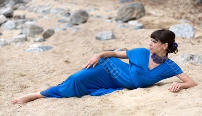 girl in a dress lying on the sand