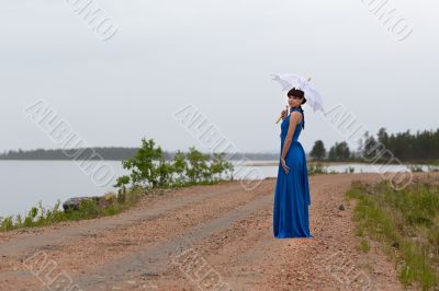Beautiful girl in a blue dress with an umbrella