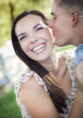 Mixed Race Romantic Couple Whispering in the Park