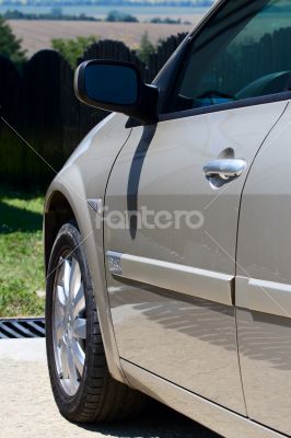 Side front of the car with a mirror and a wheel