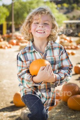 Little Boy Holding His Pumpkin at a Pumpkin Patch