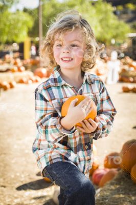 Little Boy Holding His Pumpkin at a Pumpkin Patch