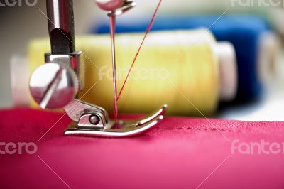 Close up of threads on fabric and sewing machine.