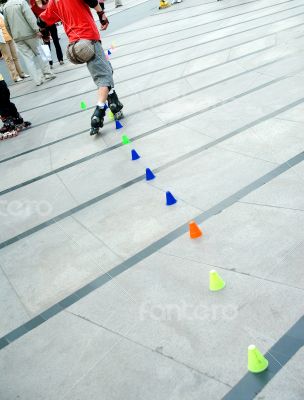 young man skating slalom on public square