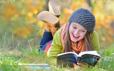 beautiful girl with book in autumn park