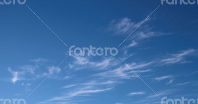 A horizontal shot of bright blue sky with puffy white clouds.