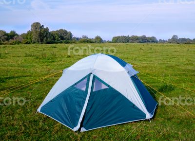 Private camping tent on the meadow near the river.