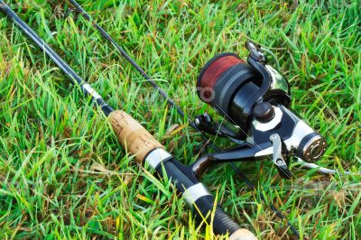 Spinning fishing on the green grass by the river.