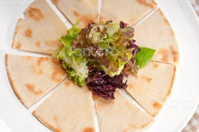 garlic pita bread pizza with salad on top