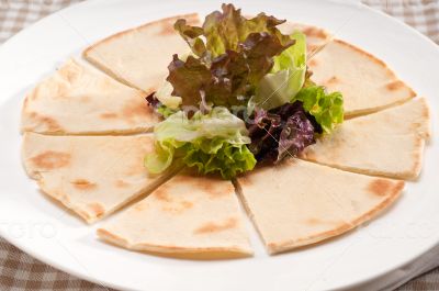 garlic pita bread pizza with salad on top