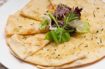 garlic pita bread pizza with salad on top