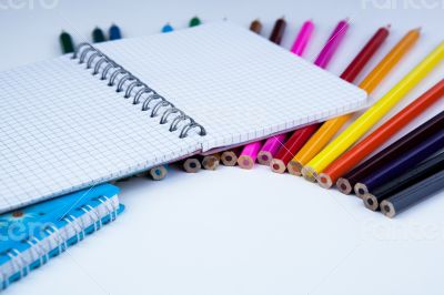 a stack of colored pencils with notebook