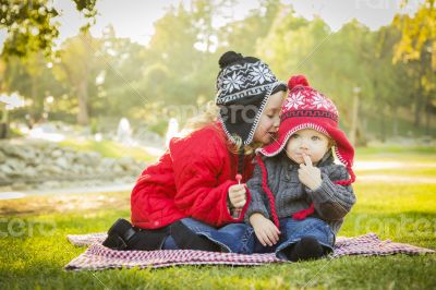 Little Girl Whispers A Secret to Baby Brother Outdoors