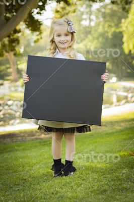 Cute Little Blonde Girl Holding a Black Chalkboard Outdoors