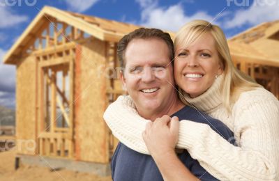 Couple in Front of New Home Construction Framing Site