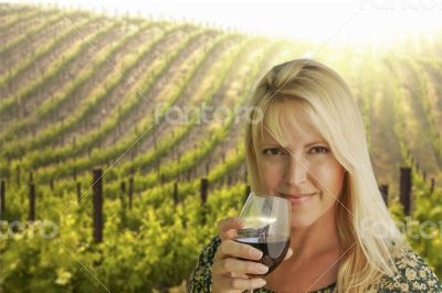 Attractive Woman Enjoying a Glass of Wine at the Vineyard