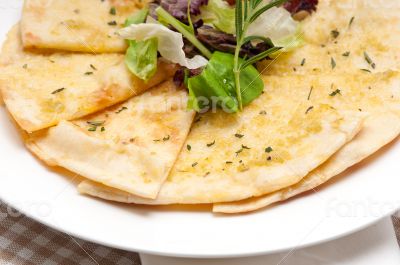 garlic pita bread pizza with salad on top