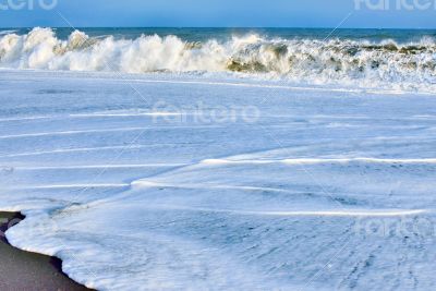 ocean wave over sand
