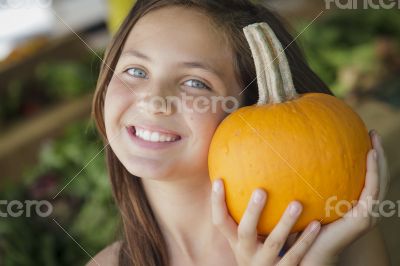 Pretty Young Girl Having Fun with the Pumpkins at Market