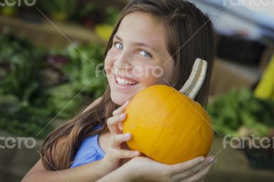 Pretty Young Girl Having Fun with the Pumpkins at Market
