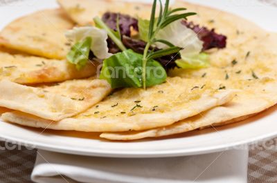 garlic pita bread pizza with salad on top