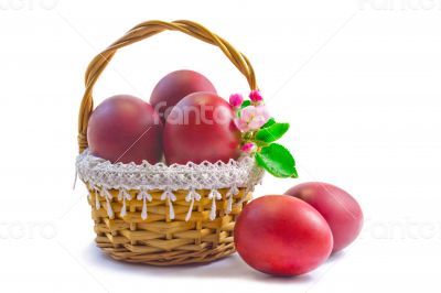 Red Easter eggs in a basket on a white background.