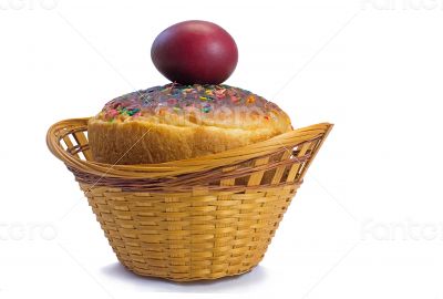 Red Easter eggs and Easter bread in a basket on a white backgrou