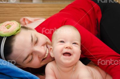 Laughing baby playing with mother