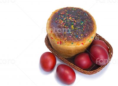 Red Easter eggs and Easter bread in a basket on a white backgrou