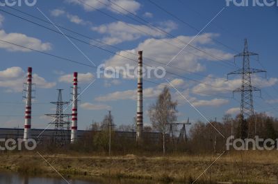 Factory pipes and high voltage power lines against the blue sky 