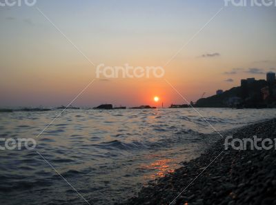 Sunset over summer sea with a small waves