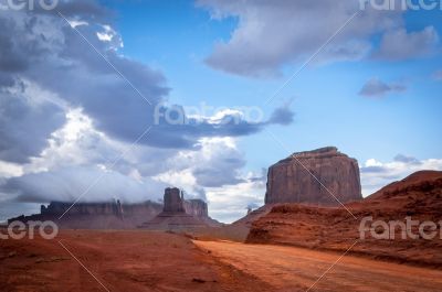 Monument valley road with big thunder cloud in background