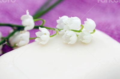Spa setting of towels, soap and lilies of the valley 