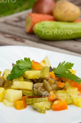 Stewed vegetables with curcuma on the white plate