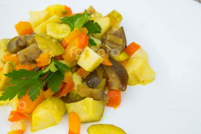 Stewed vegetables with curcuma on the white plate