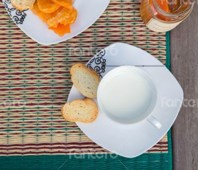A cup of milk with tangerine marmalde