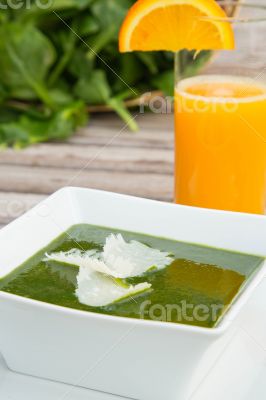 Spinach cream soup and a glass of fresh orange juice
