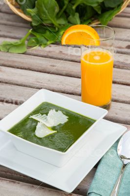 Spinach cream soup and a glass of fresh orange juice
