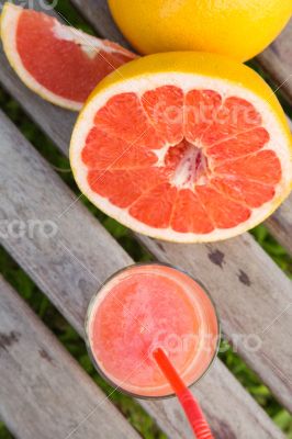 Pieces of grapefruit and a glass of fresh squeezed grapefruit ju