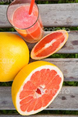 Pieces of grapefruit and a glass of fresh squeezed grapefruit ju