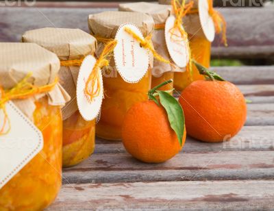 Homemade tangerine marmalade in the glass on the wooden surface