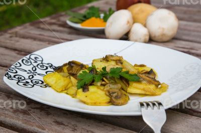 Baked potatoes with mushrooms and parsley on the white plate.