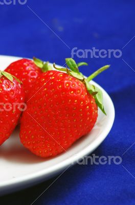 strawberries with leaves  on the plate