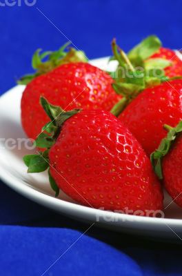 strawberries with leaves on the plate 