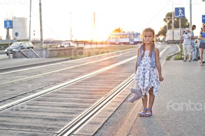 Lonely girl waiting on a city tram station