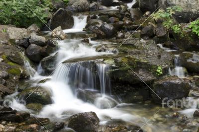 Small mountain waterfall among the rocks. 